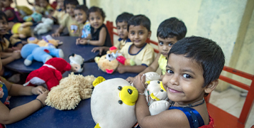 toddlers at a HOPE creche holding teddy bears