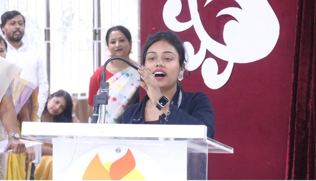 HOPE student speaking into a microphone on stage