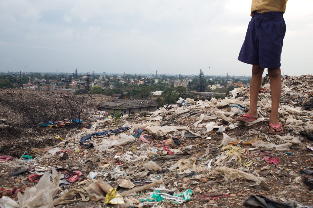 Child's feet wearing flip flops, standing on a hill