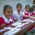 Children from HOPE's sponsorship programme sitting at desks during a lesson